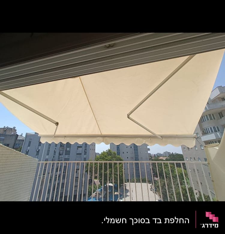 סוכך בד לבן עם זרועות מתכת על מרפסת